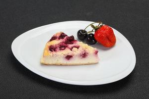 cheesecake med körsbär serveras jordgubbar foto
