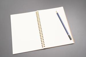 anteckningsbok med en penna. öppen spiral tom anteckningsbok med penna på vit skrivbordsbakgrund foto