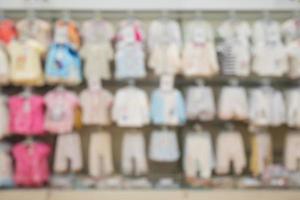 abstrakt oskärpa nyfödda babykläder hängande på hyllan på barnkläder butik för bakgrund foto