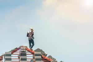 byggtäckare som installerar takpannor på husbyggarbetsplatsen foto