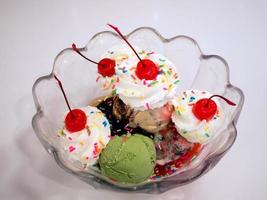 glasskulor med körsbär och vispgrädde foto