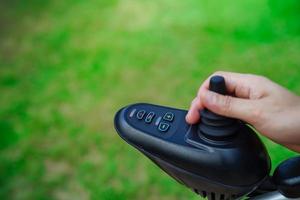 asiatisk äldre kvinna funktionshinder patient sitter på elektrisk rullstol i parken, medicinsk koncept. foto