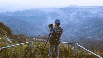 man asiater reser koppla av i semestern. fotografera landskap på mountain.thailand foto