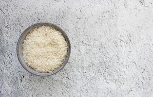 grå skål med ris på bakgrund med kopia utrymme för din text, ovanifrån. naturlig mat med hög proteinhalt foto