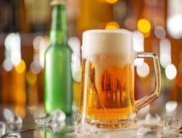 en flaska öl med glas på baren