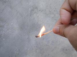 en trätändsticka som bränner en stor eld i en mans hand foto