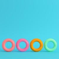 fyra färgglada uppblåsbara ringar på klarblå bakgrund i pastellfärger foto