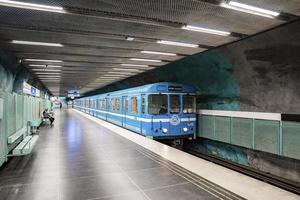 blått tåg anlände till tunnelbanan av den berömda underjordiska stadionstationen i staden foto