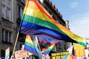 lgbtiq marsch stolthet. färgstark parad som hyllar hbtiq-rättigheter. demonstranter som går med banderoller och flaggor. mänskliga rättigheter. stolthet, passion och protest. regnbågsfamiljer. jämlikhet för alla. foto