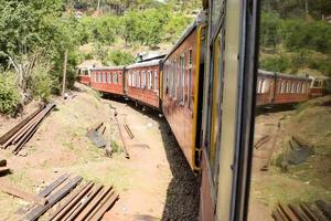 leksakståg rör sig på bergssluttningar, vacker utsikt, ena sidan berg, ena sidan dalen rör sig på järnväg till kullen, bland grön naturskog. leksakståg från kalka till shimla i Indien foto