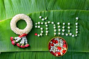 thai traditionell jasminkrans. symbol för mors dag i thailand på bananblad med kärlek mamma i thailändska ord. foto