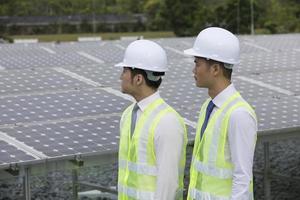 två asiatiska ingenjörer i en solpanelstation foto