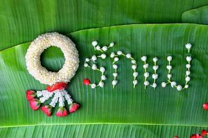 thai traditionell jasminkrans. symbol för mors dag i thailand på bananblad med kärlek mamma i thailändska ord. foto