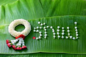 thai traditionell jasminkrans. symbol för mors dag i thailand på bananblad med kärlek mamma i thailändska ord. foto