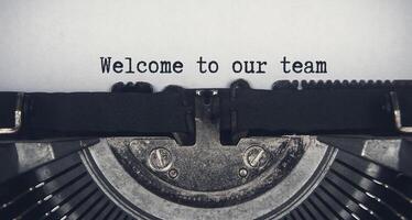 välkommen till vårt team text skriven på en gammal vintage skrivmaskin. lagarbete koncept foto