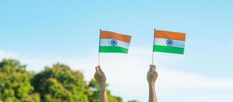 hand som håller Indien flagga på blå himmel bakgrund. semester av Indiens republik dag, glad självständighetsdagen och gandhi jayanti koncept foto