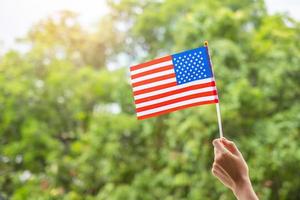 hand som håller USAs flagga på grön bakgrund. USA semester för veteraner, minnesmärke, oberoende och labor day koncept foto