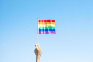 händer som visar lgbtq regnbågsflagga på naturbakgrund. stödja lesbiska, homosexuella, bisexuella, transpersoner och queer-gemenskaper och pride-månadskoncept foto