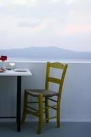 gul stol och bord med ett glas vin