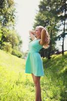 vacker glad blond kvinna i klänning utomhus livsstil foto