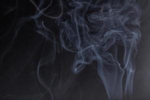 rökelse med vit rök på svart bakgrund foto