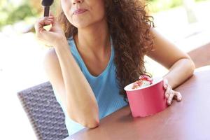 ung kvinna njuter av fryst yoghurt foto