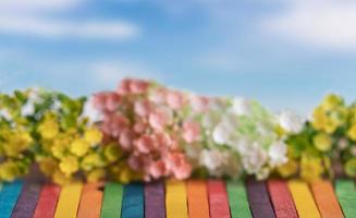 konstgjorda blommor på färgglada trä med blå himmel foto