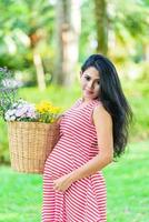 glad gravid kvinna picknick i parken foto