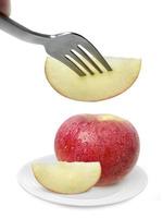 äpplefrukt på maträtt och gaffel isolerad på vit bakgrund foto