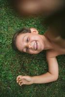 5-årig pojke som ligger på gräset och tar selfie foto