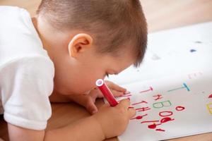 liten pojke som skriver sina första brev foto