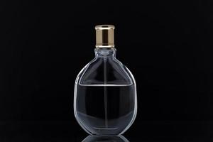 parfymflaska på svart spegelbakgrund foto