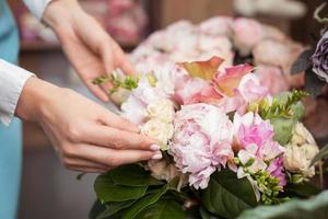 den framgångsrika unga blomsterhandlaren arbetar i hennes blomsterbutik