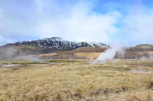 fantastisk utsikt över ångande geysirer på ett fält på Island foto