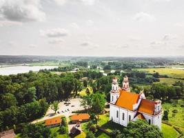 flygfoto st. apostelkyrkan jacob i kurtuvenai stad, med panoramabakgrund för den litauiska landsbygden foto