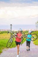 porträtt av unga kaukasiska idrottskvinnor träna med cykel utanför