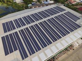 flygdrönare bild av solpaneler installerade på taket av en stor industribyggnad eller ett lager. industriella byggnader. den förnybara energin hållbara källor grön el solceller. foto