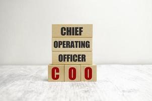 ordet coo på träblock, vit bakgrund, affärsidé. affärer och finans foto
