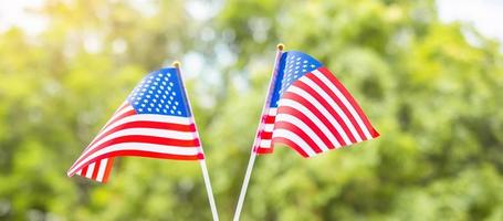 hand som håller USAs flagga på grön bakgrund. USA semester för veteraner, minnesmärke, oberoende och labor day koncept foto