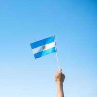 hand som håller Argentina flagga på natur bakgrund. 9 juli självständighetsdagen, 25 maj revolutionsdagen och glada firande koncept foto