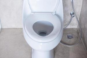 ny keramisk toalettskål och toalettpapper. städning, wc, livsstil och personlig hygien koncept foto