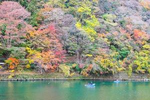 färgglada lövberg och katsurafloden i arashiyama, landskapslandmärke och populärt för turistattraktioner i Kyoto, Japan. höst höstsäsong, semester, semester och sightseeing koncept foto