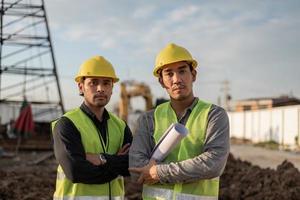 ingenjörer män som arbetar på byggarbetsplatsen. asiatiska arbetare män står och korsade armar på byggarbetsplatsen. foto