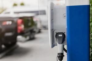 elbilsladdningsstation för laddning ev batteri i bilparkering. grön kraft och framtida transportteknikkoncept. foto