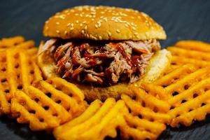 kryddig pulled pork med gyllene pommes frites foto