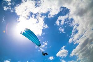paraglider svävar i en solig blå himmel foto