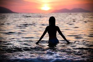 underbar passform kvinna siluett simma i sunset.free kvinna njuter av solnedgången. foto