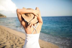 sommarmode kvinna njuter av sommar och sol, promenader på stranden foto