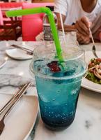 närbild kopp med blå hawaii läsk cocktail på bordet foto