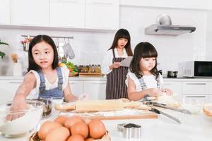 attraktiv ung kvinna och dotter söt dotter lagar mat på kök foto